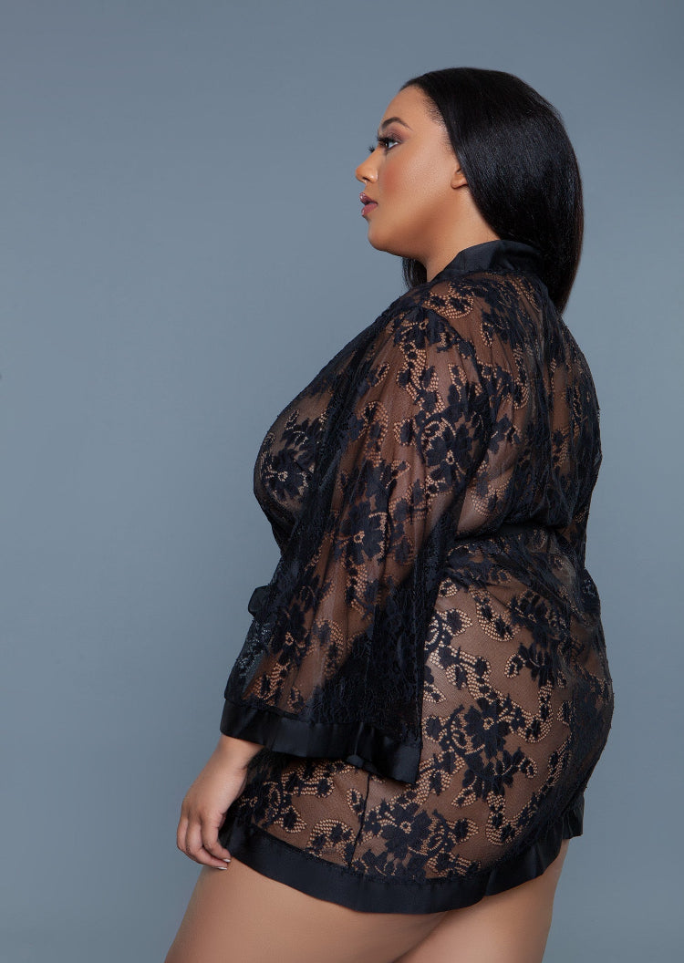 Woman wearing a black lace outfit against a gray background